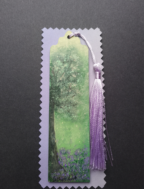 A decorative bookmark featuring a hand painted green and purple tree, purple bluebell flowers below the tree, a lilac purple tassel on lilac packaging on a black background. Original hand  bookmark by Cathy's Art*