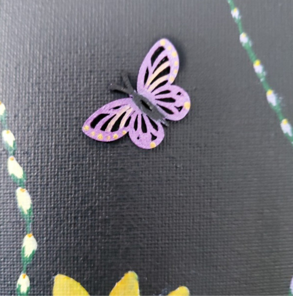 A small butterfly-shaped embellishment in lavender purple with black antennae and small gold dots, placed on a black canvas background with floral details. Original acrylic painting by Cathy's Art*