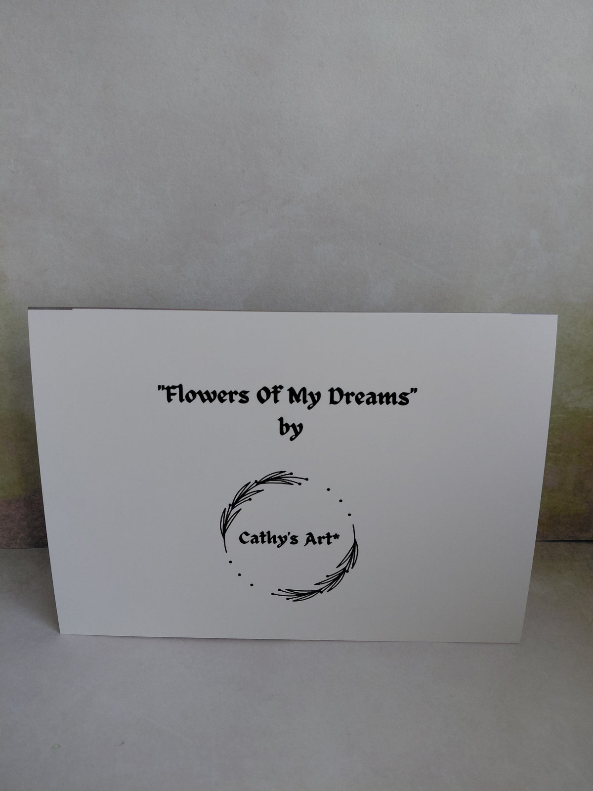 A white rectangular printed card against a light wall, with black text reading “Flowers Of My Dreams” by Cathy's Art". This is the back of a printed greeting card by Cathy's Art*