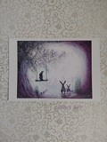 A whimsical scene featuring a tree, glowing moon, three hares starring at the moon, one sat on a swing in the tree. Purple and turquoise colours. Artwork by Cathy's Art*