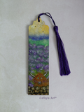 A hand-painted wooden bookmark featuring a Highland cow in a purple lavender field under a yellow and blue sky, complete with a purple tassel, displayed on a light textured background. By Cathy's Art*