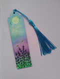 A hand painted bookmark with a blue tassel, featuring a painted lavender field under a yellow sun and purple sky on a lilac background. By Cathy's Art*