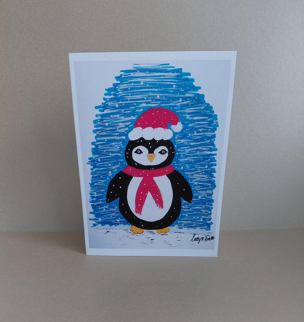 A cute festive printed artwork Christmas card, a black & white penguin wearing a Santa hat against a blue snowy backdrop. Original artwork & printed by Cathy's Art*