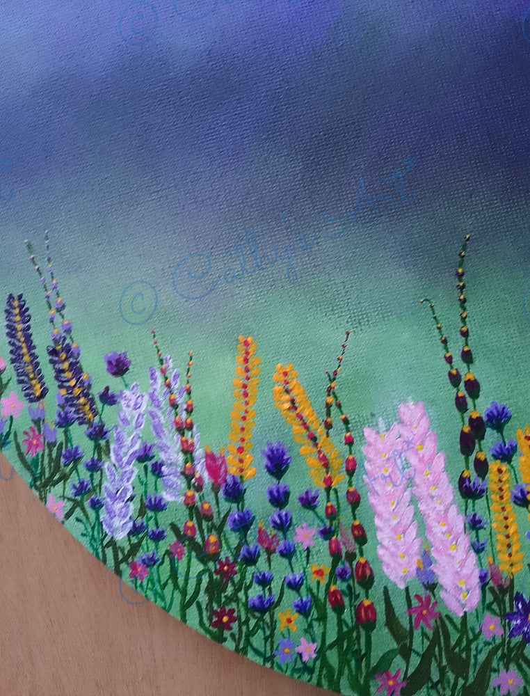 A close-up of a painted canvas showing a field of colourful wildflowers against a blue-to-green gradient sky. The painting includes purple, pink, yellow, orange, and green tones. Original acrylic painting by Cathy's Art*