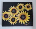 A black canvas painting featuring six yellow sunflowers with gold edging to the petals, displayed against a white wall. The artist's signature 'Cathy's Art*' is visible in the bottom right corner. Original acrylic sculptured painting by Cathy's Art*