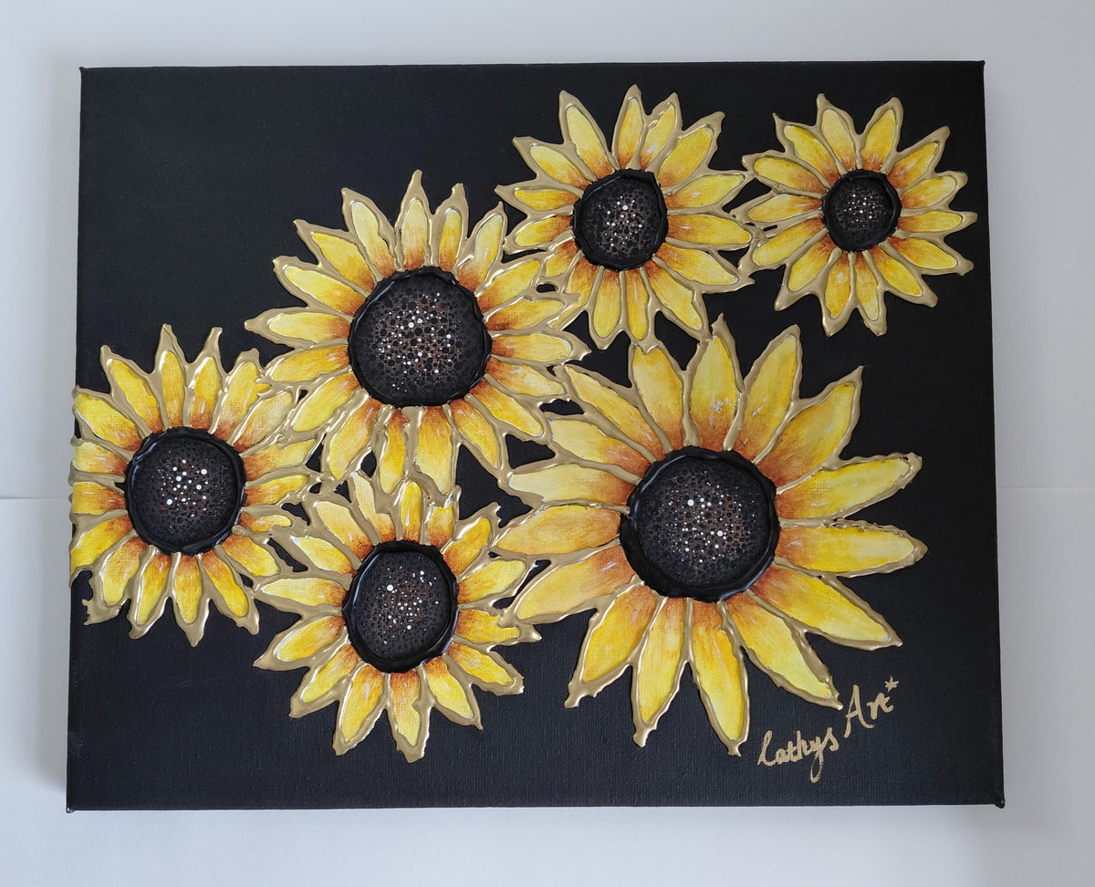 A black canvas painting featuring six yellow sunflowers with gold edging to the petals, displayed against a white wall. The artist's signature 'Cathy's Art*' is visible in the bottom right corner. Original acrylic sculptured painting by Cathy's Art*
