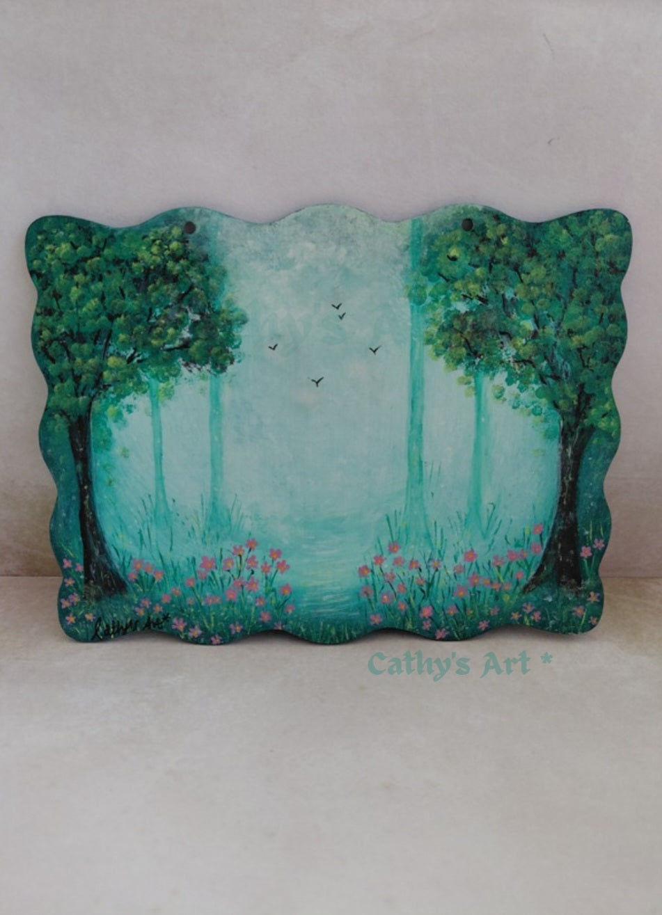 A hand-painted wooden plaque featuring a whimsical forest scene with green trees, a misty teal sky, birds flying and small pink flowers, displayed against light background. Original acrylic painting on wooden plaque by Cathy's Art*
