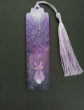A hand painted wooden bookmark with a tassel, featuring a purple forest illustration with a hare and moon, shown against a black background. By Cathy's Art*