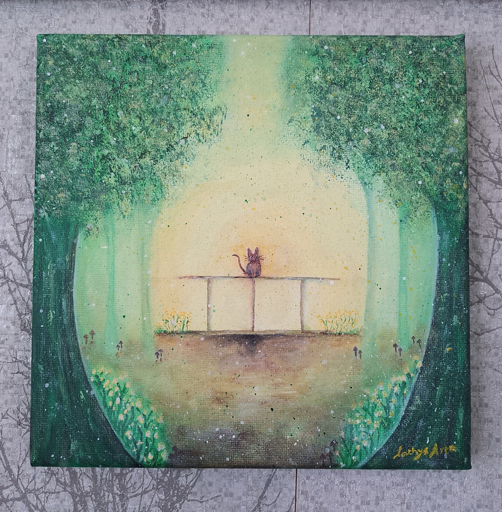 A square canvas painting featuring a small cat sitting on a fence in a misty green forest clearing, with tall trees framing the scene and a pale glowing  yellow background. With tiny mushrooms and yellow flowers. The painting is photographed against a textured grey surface. Original acrylic canvas painting by Cathy's Art*